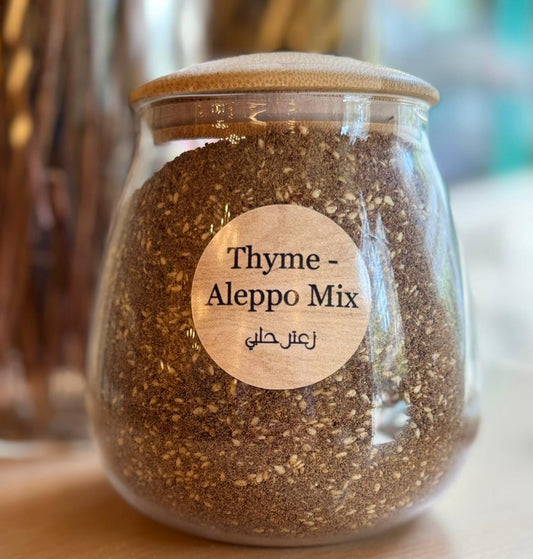 Glass jar with Thyme Aleppo Mix and wooden lid on a blurred background