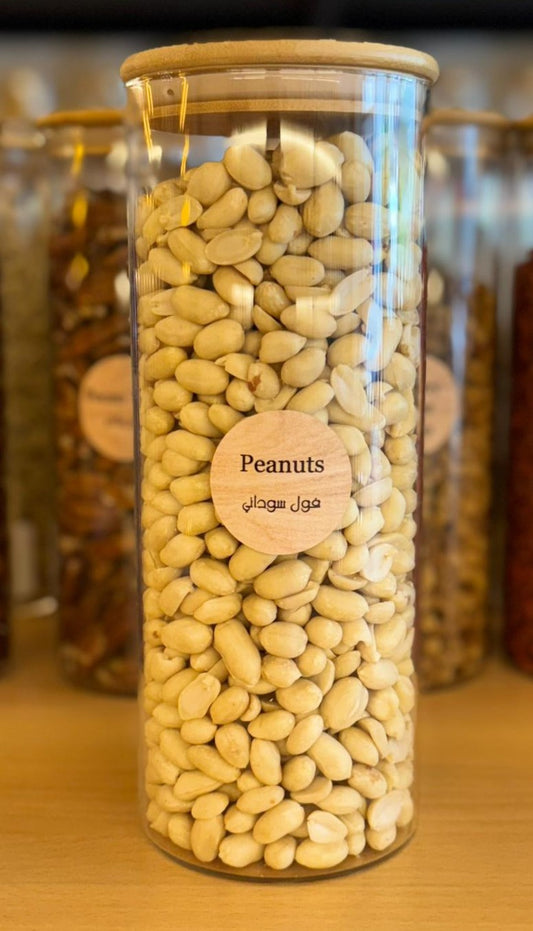 Glass jar filled with peanuts on a wooden surface